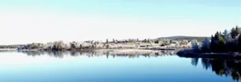 Glace craquelée sur un lac gelé avec des montagnes enneigées sous un ciel nuageux au loin, rappelant les paysages pittoresques près d'Irkutsk. - AEROAFFAIRES